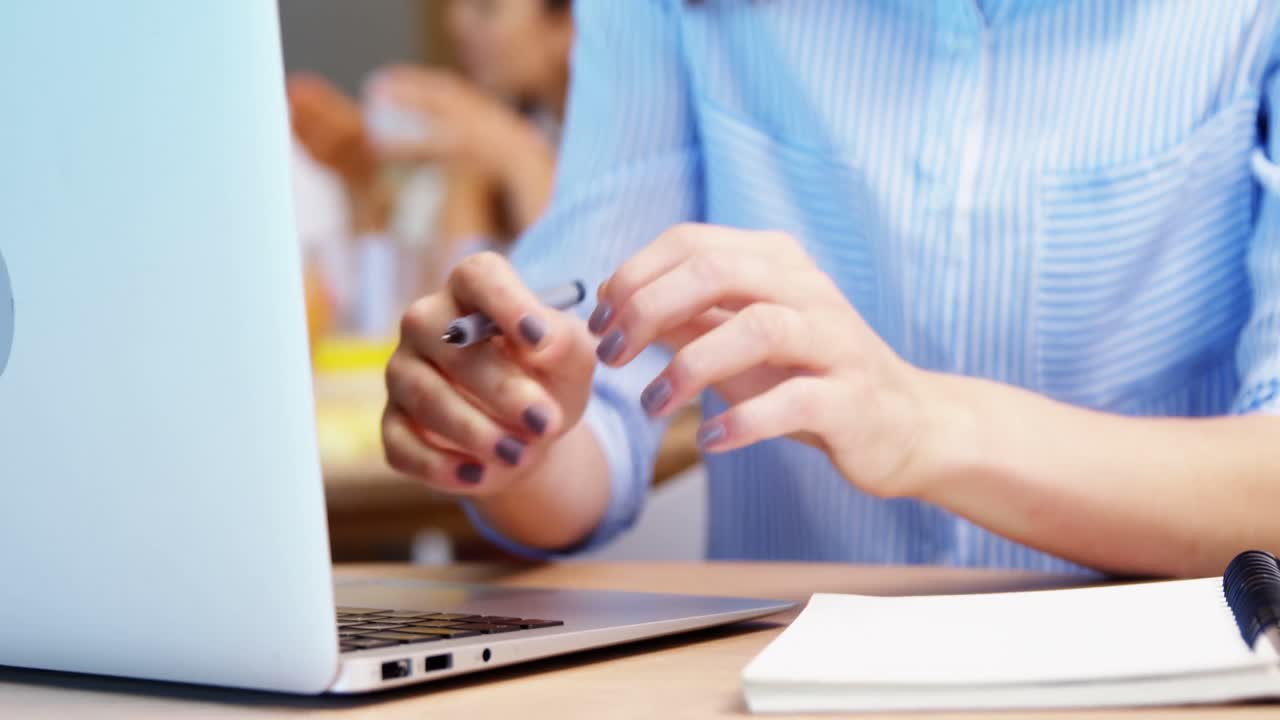 mujer ejecutiva usando portátil y escribiendo en diario