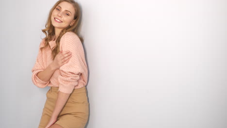 mujer con un suéter rosa y pantalones cortos caqui