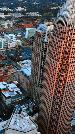panoramic view on the diverse architecture in the downtown of charlotte, north carolina, usa. cityscape in the rays of setting sun from top. vertical video