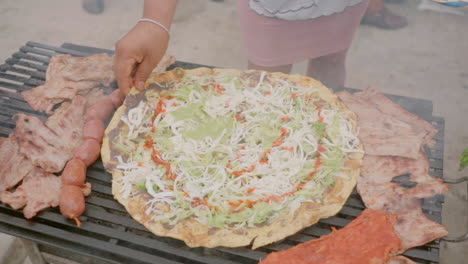 preparing traditional food tlayuda with traditional oaxaca cheese quesillo