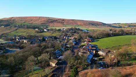 aerial footage of the small village of denshaw, and the church and graveyard, a typical rural village in the heart of the pennines