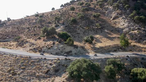 Parallele-Drohnenaufnahme-Von-Drei-Rollern,-Die-Auf-Einer-Bergstraße-Auf-Der-Insel-Kos-Fahren