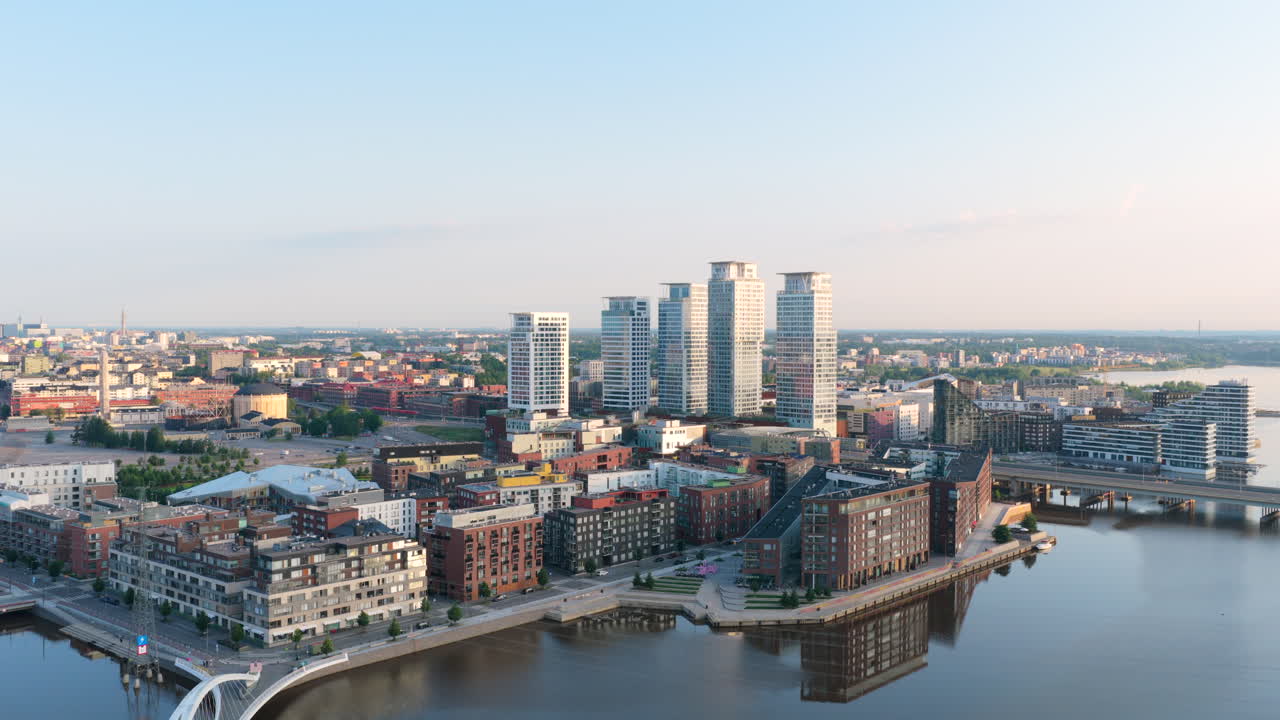 Drone circling the Kalasatama district with high-rise, golden hour in Helsinki