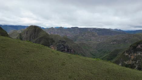 aerial pulls back as hiker jogs down mountain ridge, codo de los andes