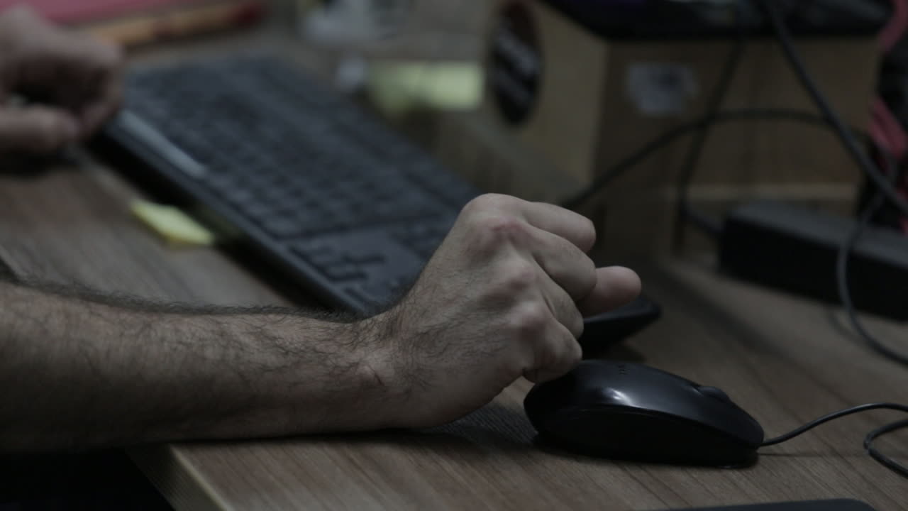 la mano de un hombre trabajando en un mouse de computadora
