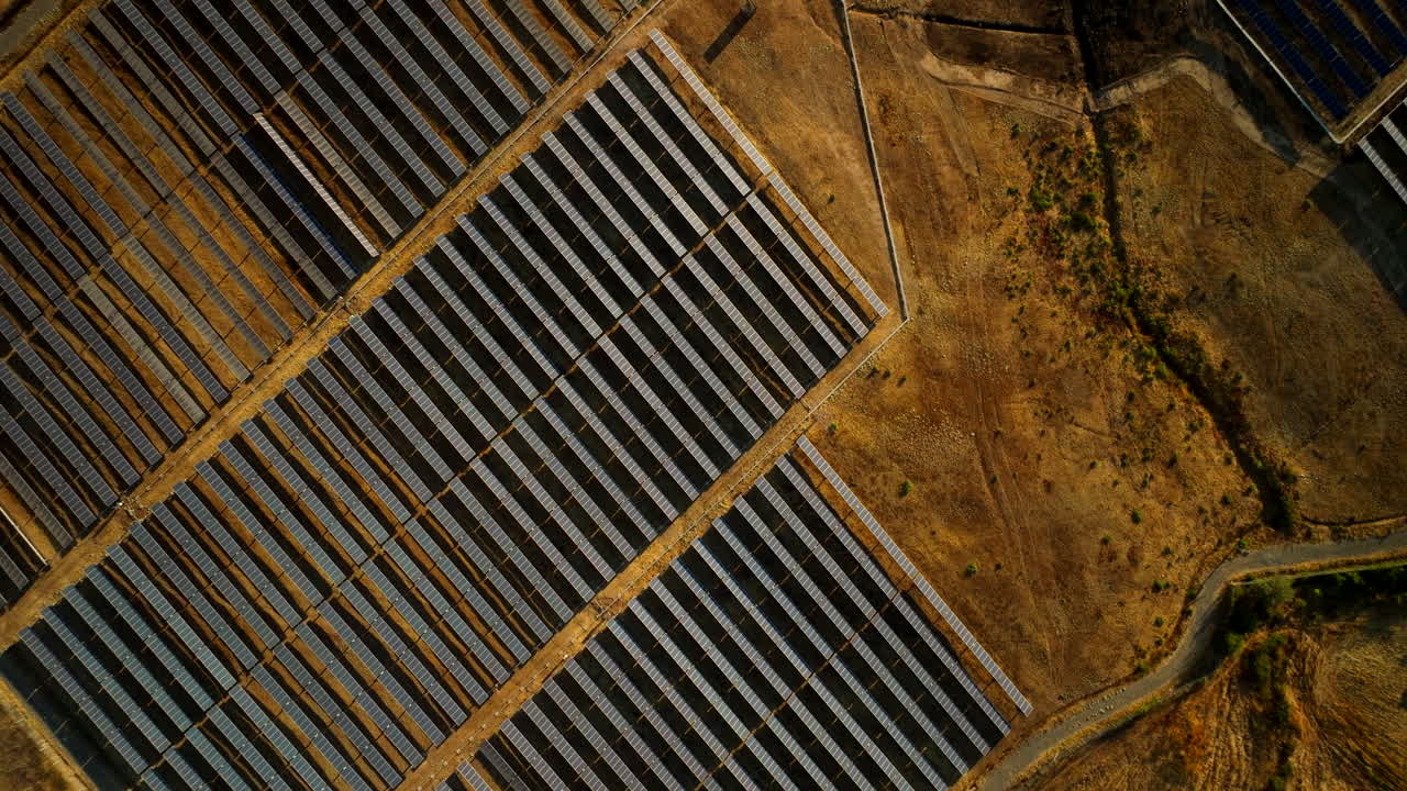 Dronebillede fra fugleperspektiv over solcellepark med solcellepaneler i tørt landskab