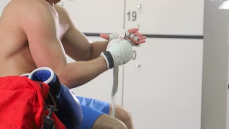 young athlete sitting in the locker room at the gym boxer practices boxing punches in locker room before fight boxing punches