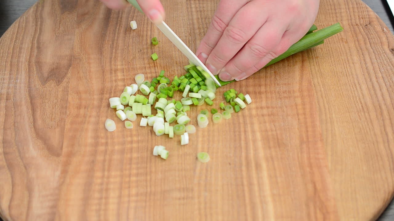 Vi skærer løg på et bræt. Optagelse i køkken.