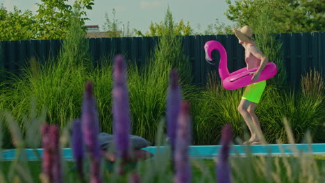 hombre con flamenco inflable en la piscina