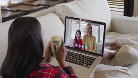 Mixed-race-woman-on-laptop-video-chat-having-coffee-at-home