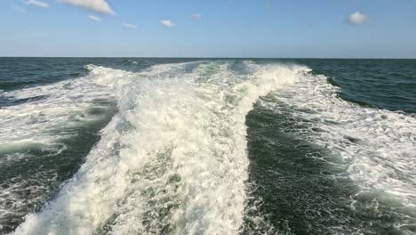wake-of-water-seen-from-behind-of-fast-moving-motor-boat-in-a-clear-sky-day,-Blue-sea,-water-surface