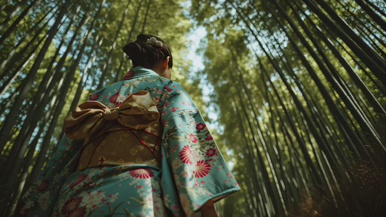 Filmato cinematografico a bassa angolazione di una donna in kimono floreale che cammina attraverso un boschetto di bambù illuminato dal sole, concetto sereno di viaggio e cultura con imponenti steli verdi.