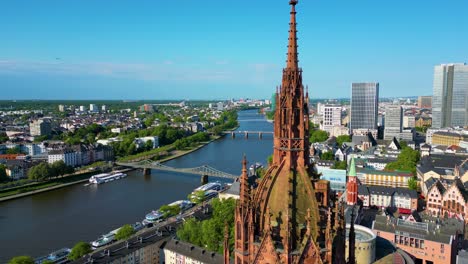 4k aerial drone video of the historic kaiserdom st. bartholomäus church on the banks of the main river in downtown frankfurt, germany