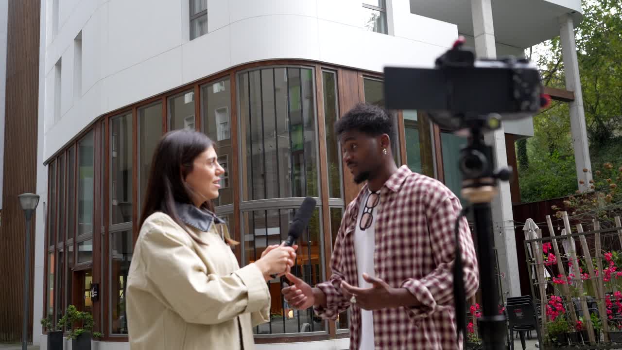 Reporter Interviews Man Outdoors with Camera Recording