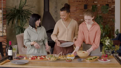 un amistoso grupo multiétnico de tres mujeres puso la mesa para una reunión de amigos