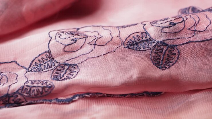 Primo piano di tessuto rosa con ricamo floreale