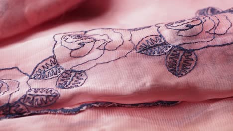 close-up of pink fabric with floral embroidery