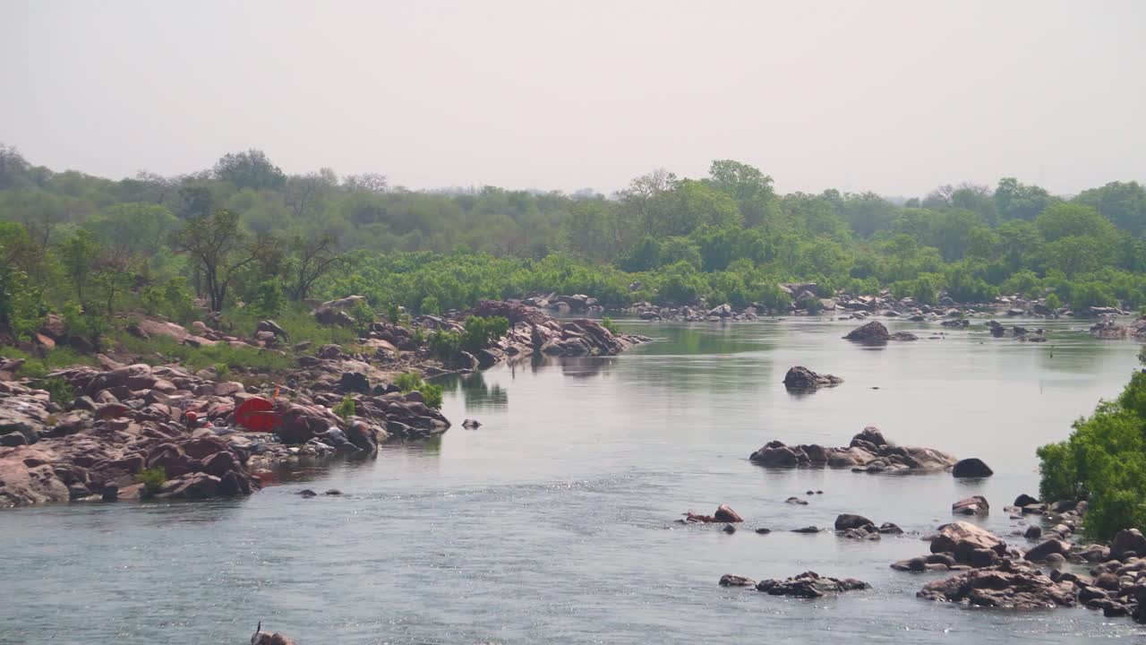 pan shot del río betwa que fluye a través de terreno rocoso en las orillas del bosque cerca de orchha en madhya pradesh india