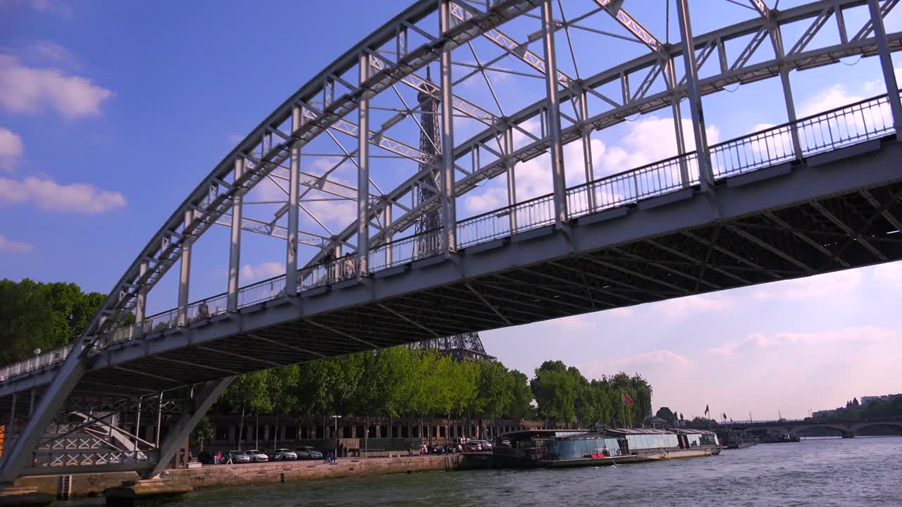 A point of view of the Eiffel Tower from a bateaux mouche riverboat traveling along the Seine River in Paris