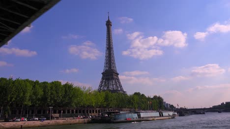 a point of view of the eiffel tower from a bateaux mouche riverboat traveling along the seine river in paris