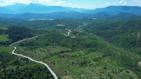road winding through vineyards and mountains range green forest, albania greece border near scenic leskovik