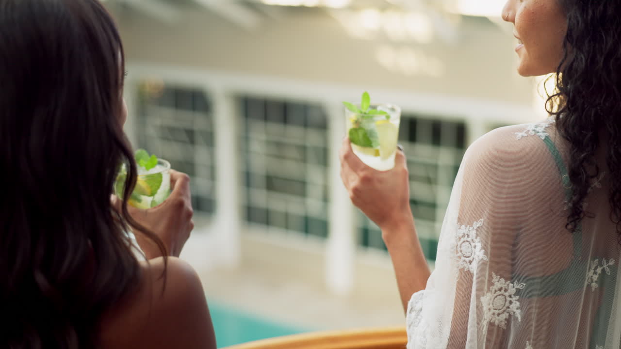 Women enjoying cocktails by the pool