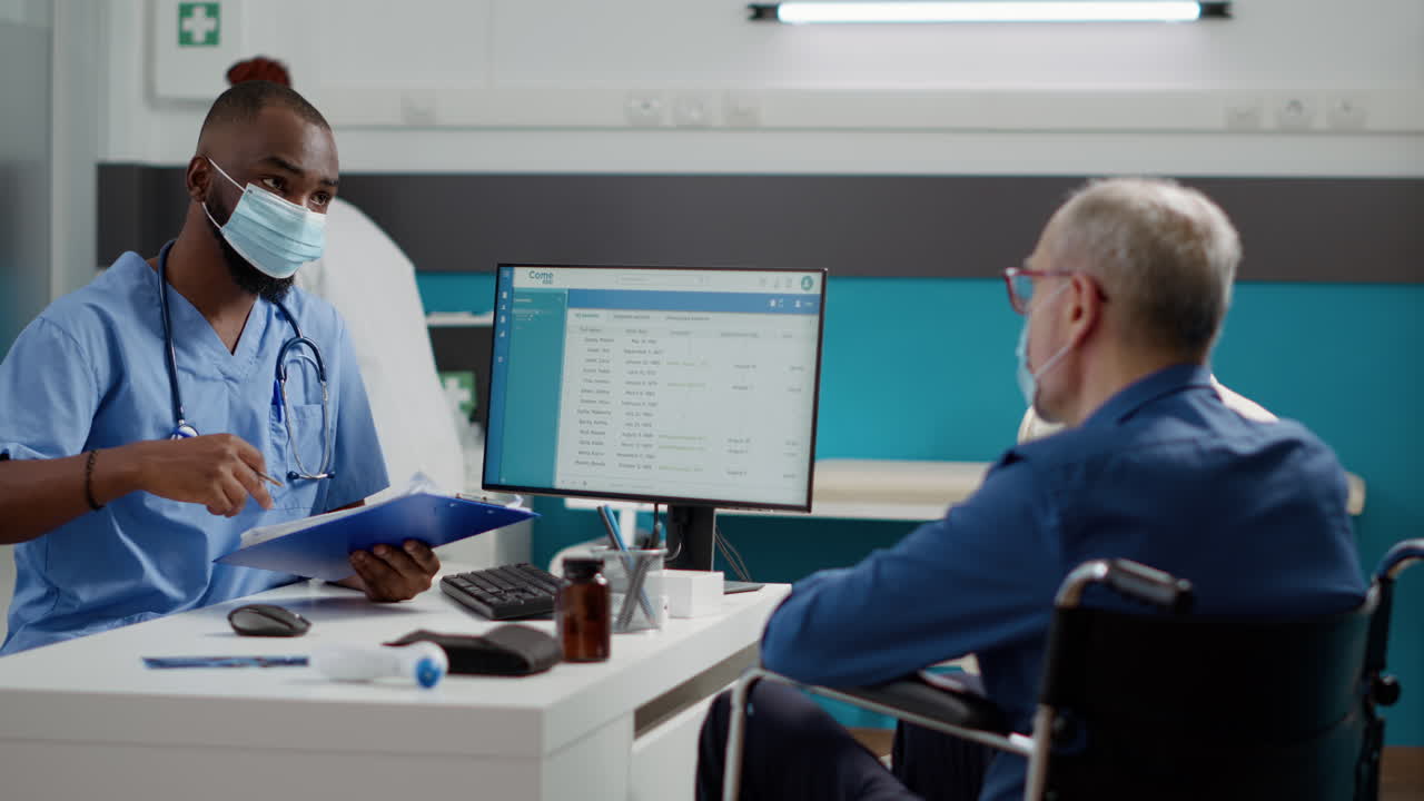 Doctor consulting with elderly patient in wheelchair at clinic