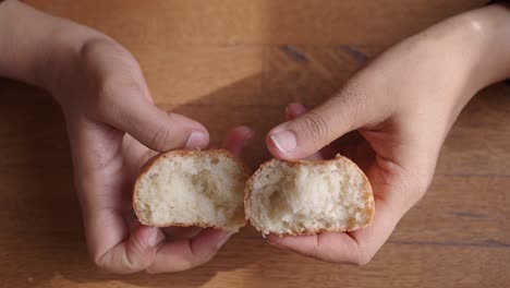 close up of a soft, white bread roll being held in hands