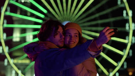 Smiling-couple-taking-selfie-on-smartphone.-Man-and-woman-grimacing-on-camera.