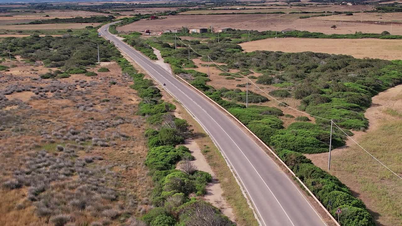 Vasto paesaggio e strada trafficata in Sardegna durante il giorno