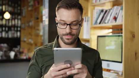 man using tablet in modern coffee shop