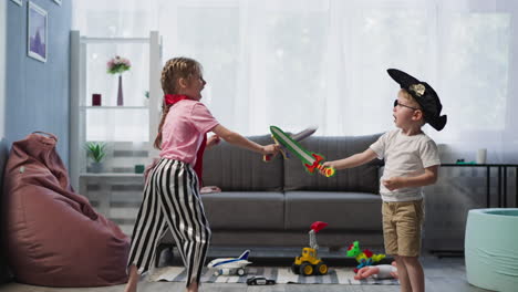 Un-Niño-En-Edad-Preescolar-Y-Un-Niño-Pequeño-Juegan-A-Duelo-Con-Espadas-En-El-Salón