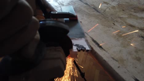 worker cutting iron steal with angle grinder, making metal stamp logo for small business
