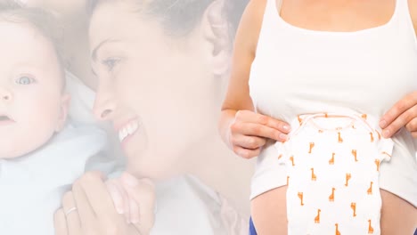 animation of happy caucasian woman with baby and pregnant caucasian woman holding baby clothes