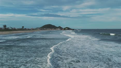 drone advancing over perfect waves at praia grande in são francisco do sul, brazil