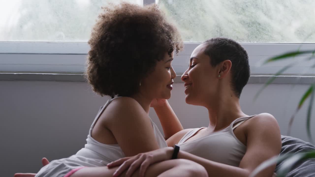 Lesbian couple kissing each other in bedroom