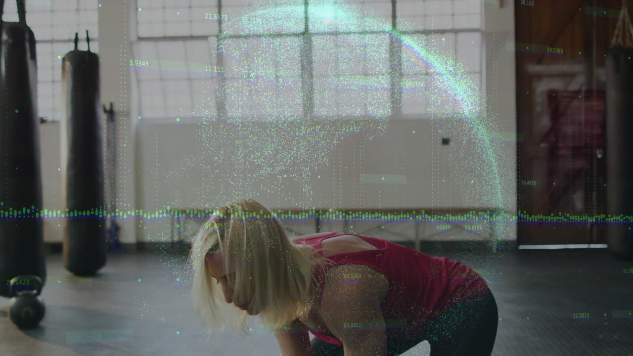 Female athlete initiating kettlebell swing by grasping weight, powering upward for fitness training