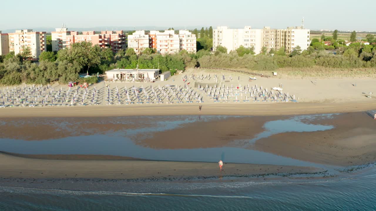 toma aérea de playa de arena con sombrillas y miradores