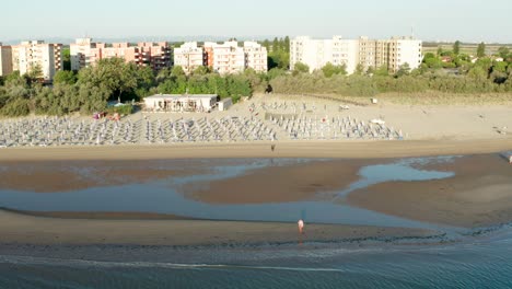 aerial shot of sandy beach with umbrellas and gazebos