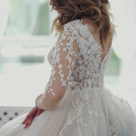 sexy model in wedding dress posing in studio on the background of flowers. gorgeous young bride in a beautiful white wedding dress is sitting in the room.