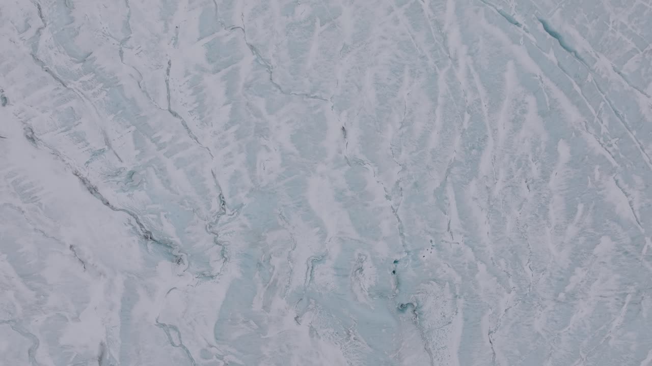 vista aérea de las grietas y formaciones de hielo en el glaciar virkisjokull cubierto de nieve, islandia