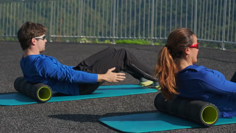 couple doing foam rolling exercise outdoors