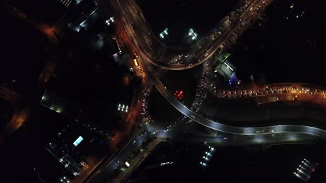 experience the vibrant energy of the city at night with this top-down drone view of road traffic and city lights