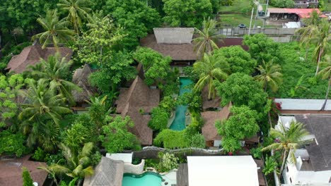 aerial pan down of tropical pool villas on gili trawangan island