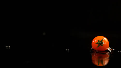 tomato rolling on water against black background 4k