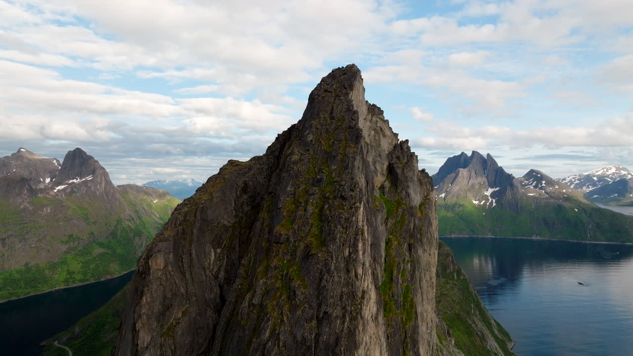 Sorvolo di un drone sulla vetta rocciosa del monte Segla, sullo sfondo fiordi e catene montuose. Norvegia