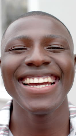 vertical video of portrait of happy african american man smiling, slow motion