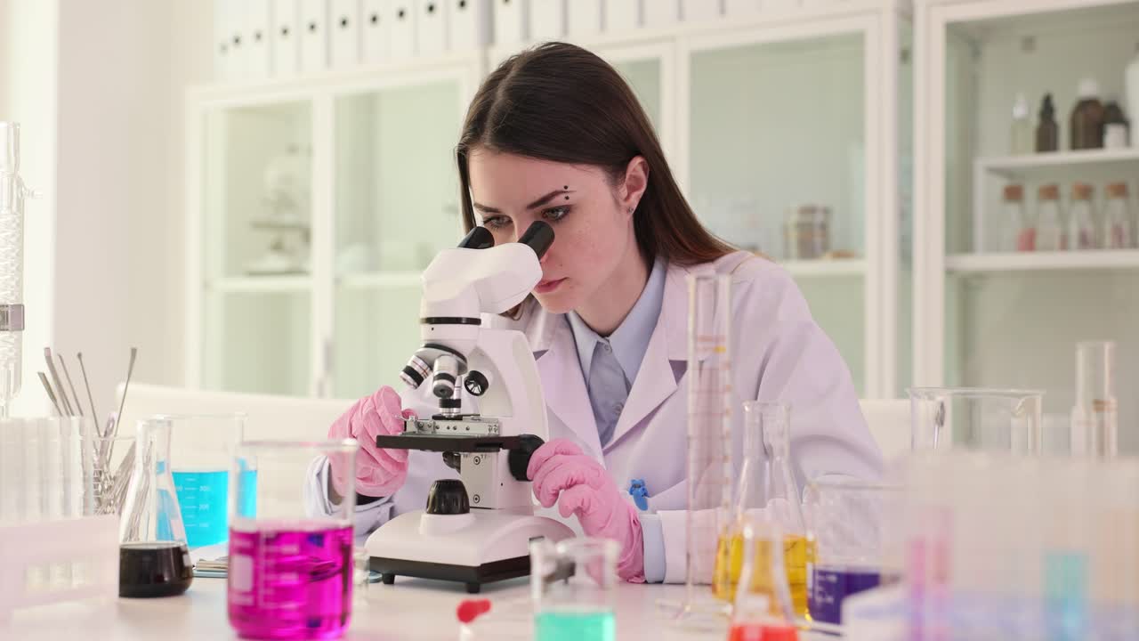 A woman scientist conducting an experiment in a laboratory using a microscope
