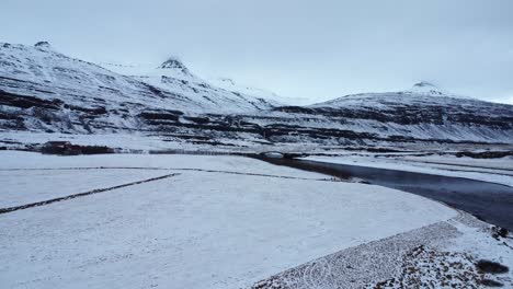 river with bridge near snowy mountains