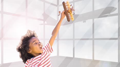 Animation-of-happy-african-american-boy-playing-with-plane-toy-over-silhouette-of-plane